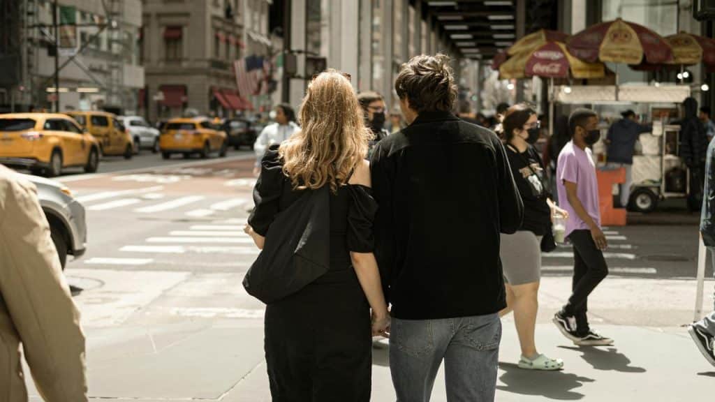A couple walking down a busy city street.
