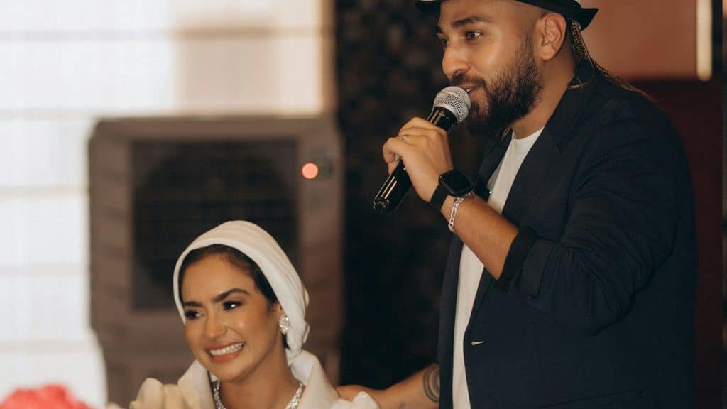 A man holding a microphone standing next to a woman.