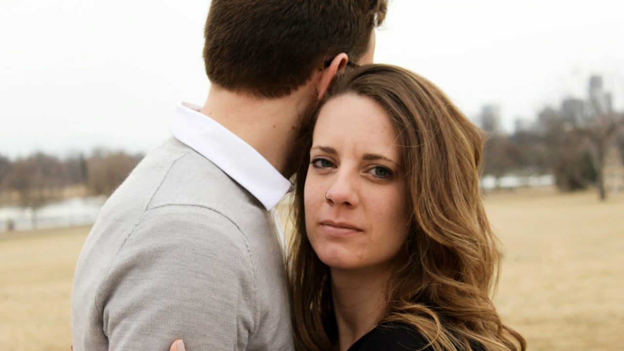 A man and a woman each other outdoors.