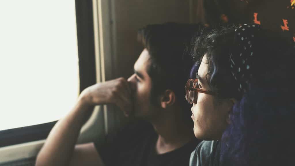 A sad man and a woman looking at the window.