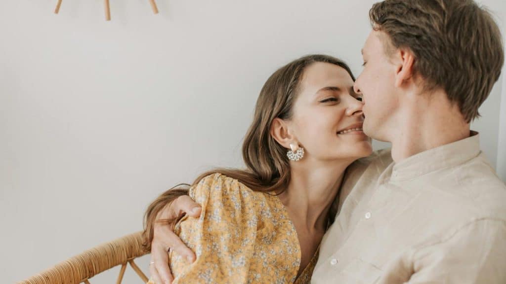 A couple smiling closely as they embrace.