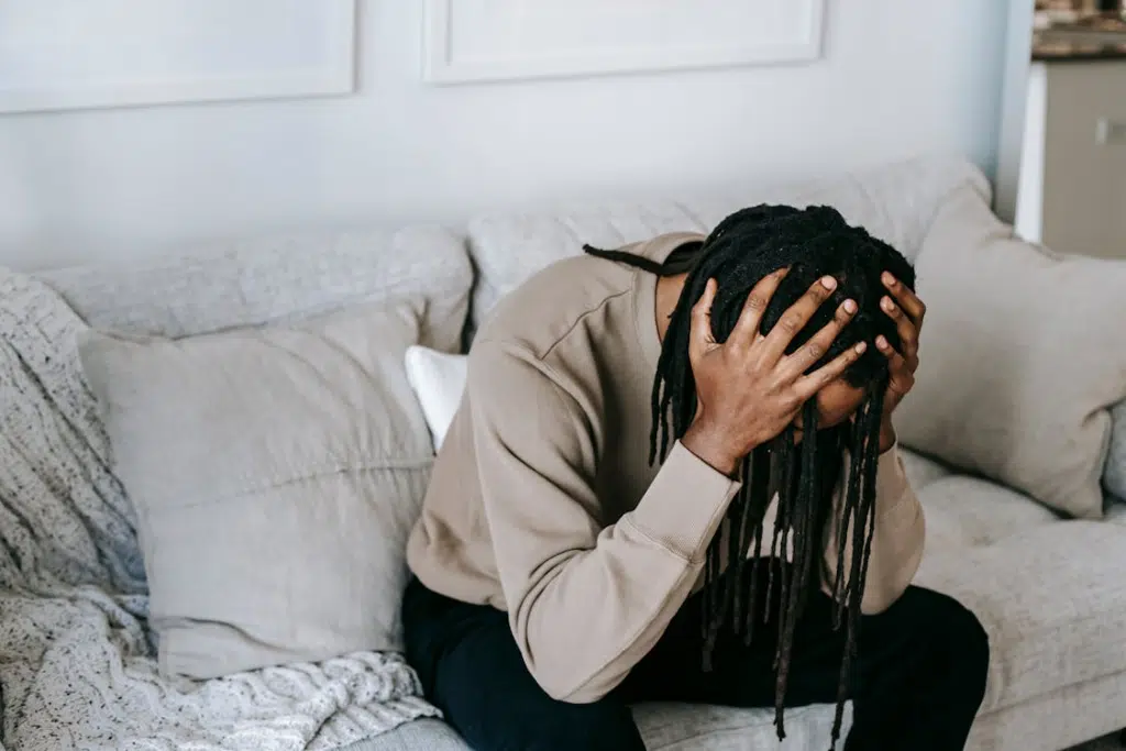 A stressed man sitting on a sofa