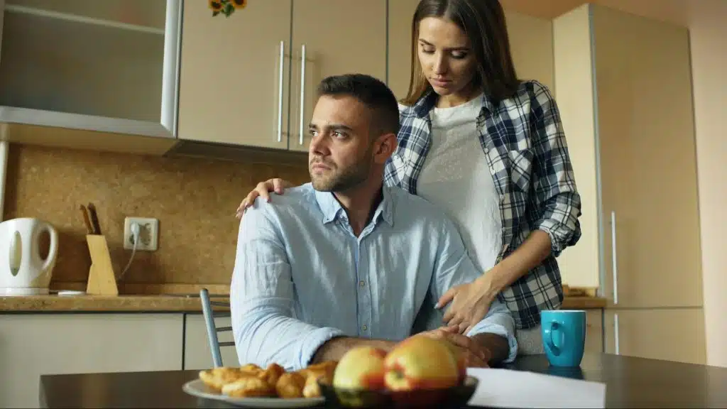 A woman holding the shoulder of a man