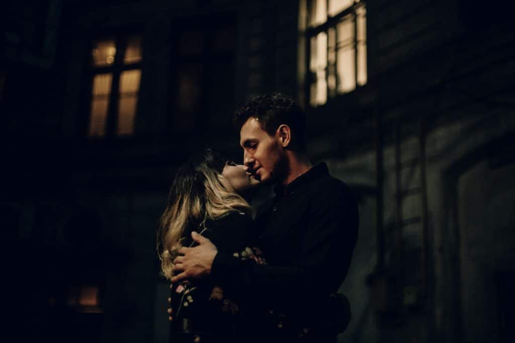 The couple is about to kiss outside.