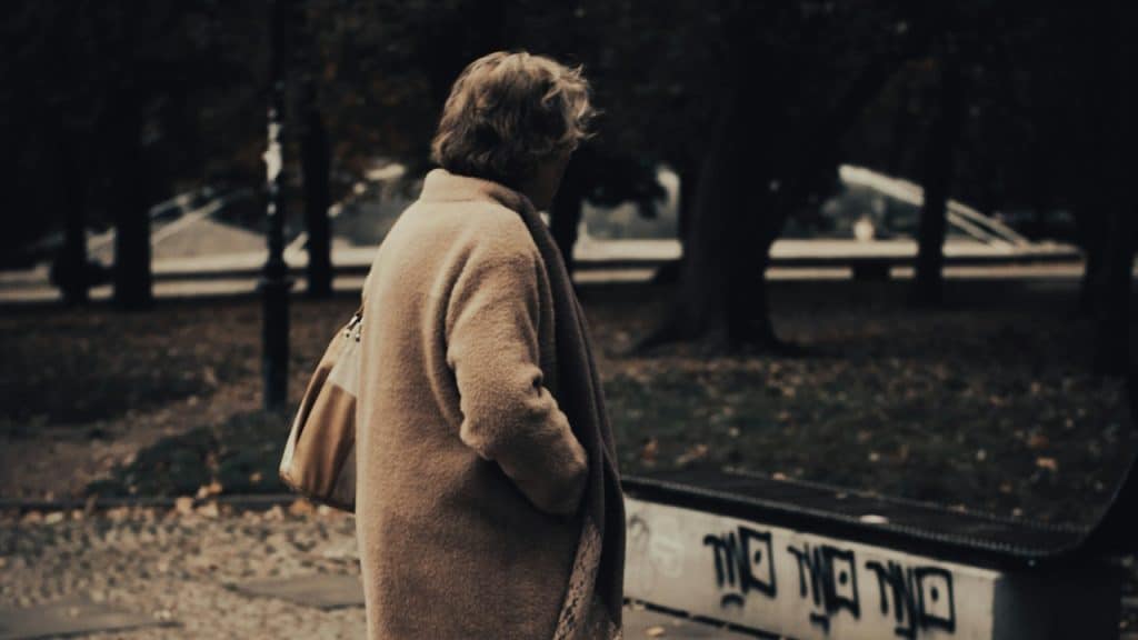 A woman standing alone in a park.
