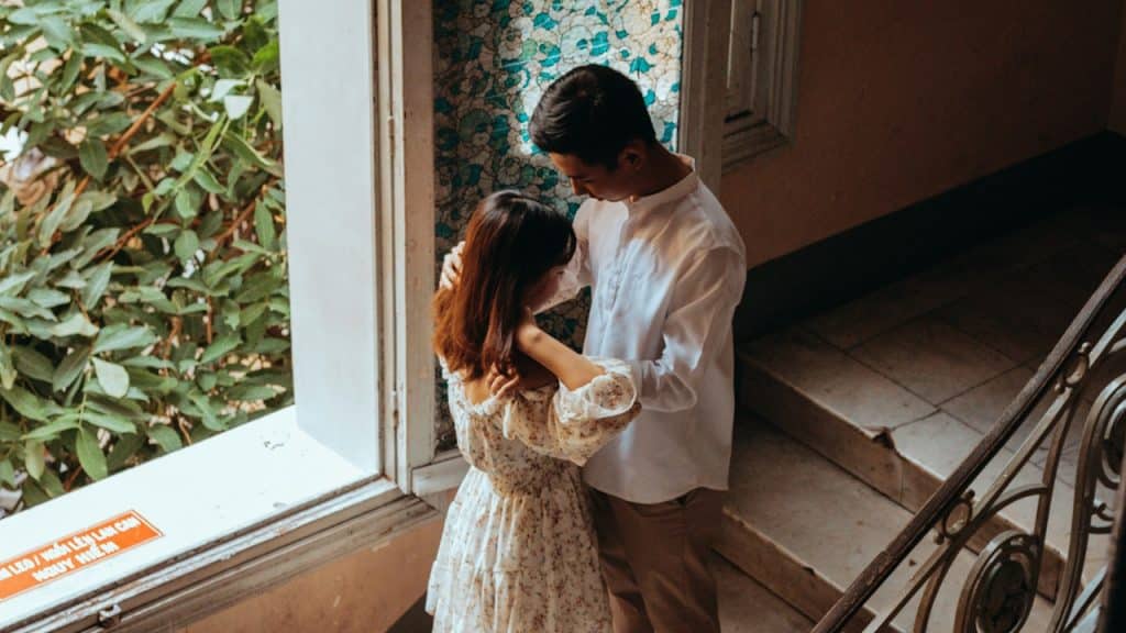 A woman in a white dress standing on stairs.