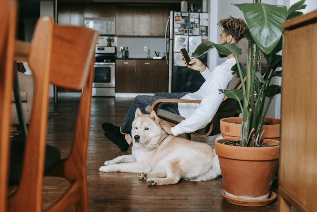 A man using a phone while petting a dog