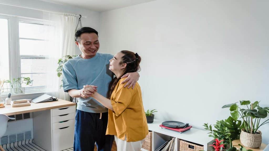 A couple smiling while dancing 