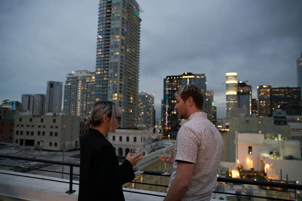 The couple is talking at a rooftop bar.