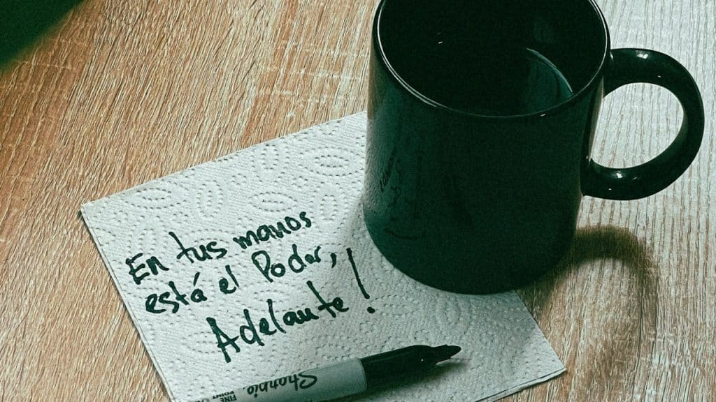 A cup of tea with a note on the table.