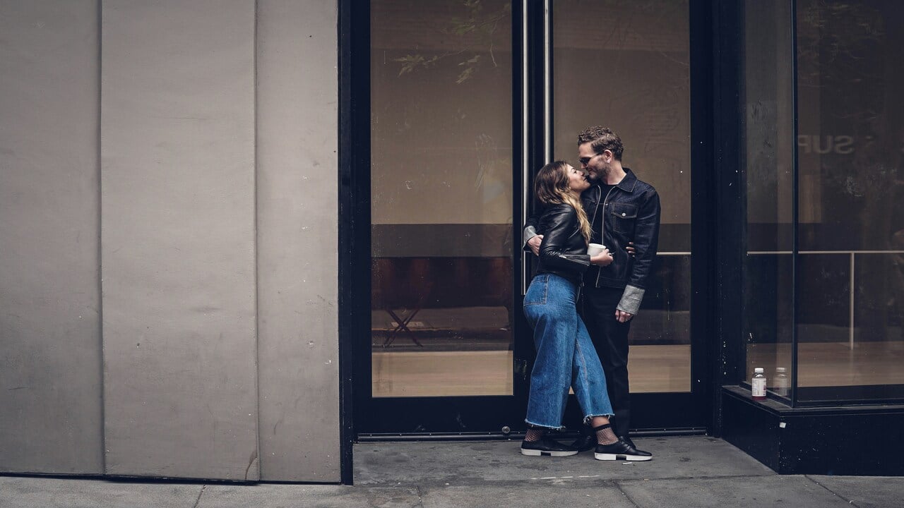 A couple kissing by the door