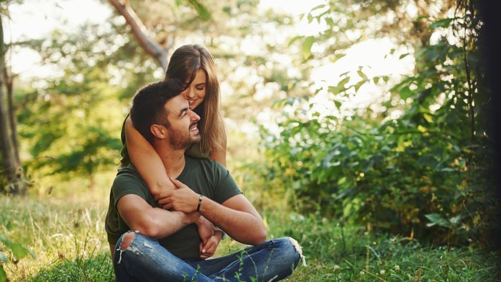 A beautiful couple embracing each other in the forest at daytime.