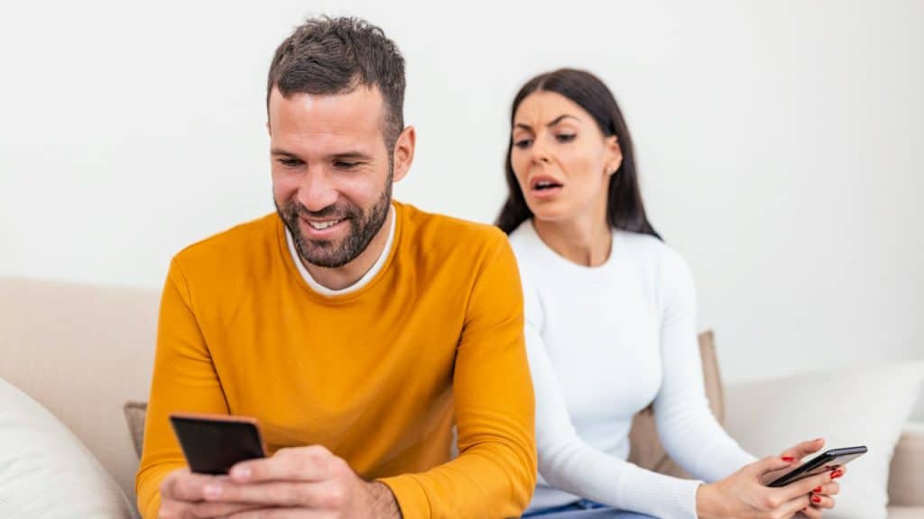 A woman reading text messages of her husband.