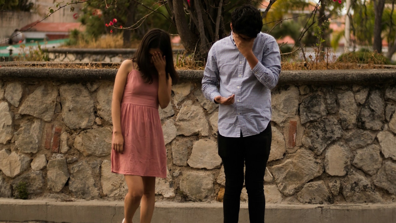 A man and woman on a concrete pathway at daytime.