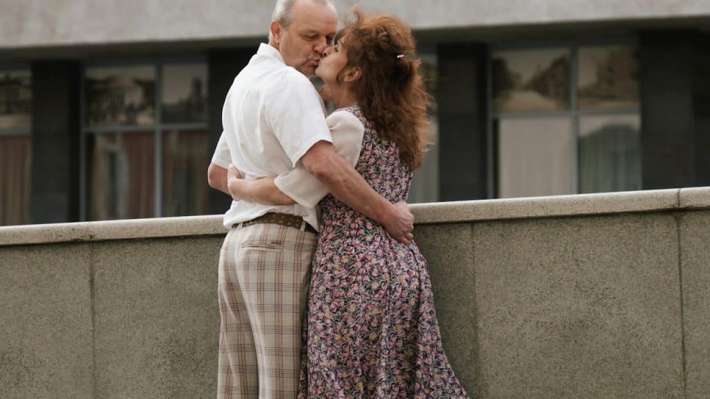 A man and a woman hugging each other outdoors.