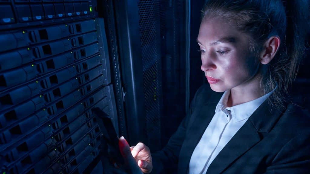 Closeup of a serious woman wearing a suit is using a phone.