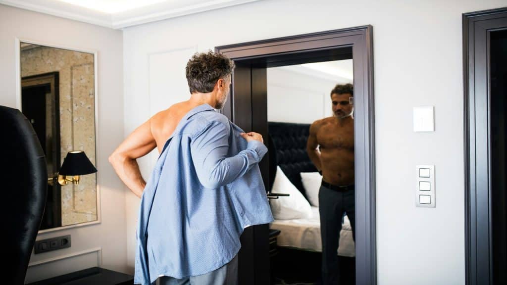 A man changing in front of a mirror
