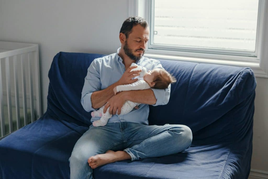 A mature dad holding his newborn baby.