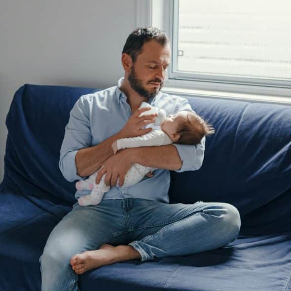 A mature dad holding his newborn baby.