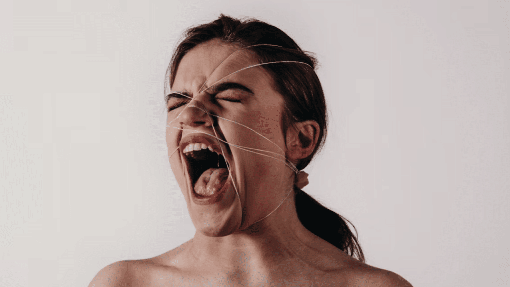 A woman looking angry with yarn on her face 