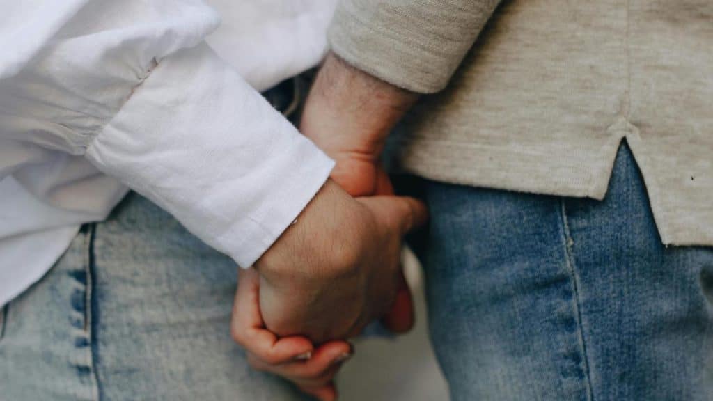 A close-up of two people holding hands.