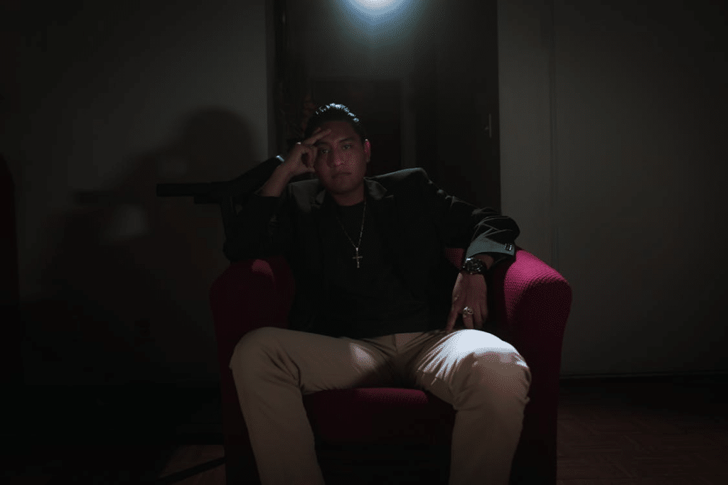 Man Sitting in an Armchair in a Dark Room