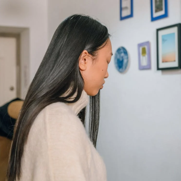 Upset woman standing in the hallway in an apartment with a man dressing to go out