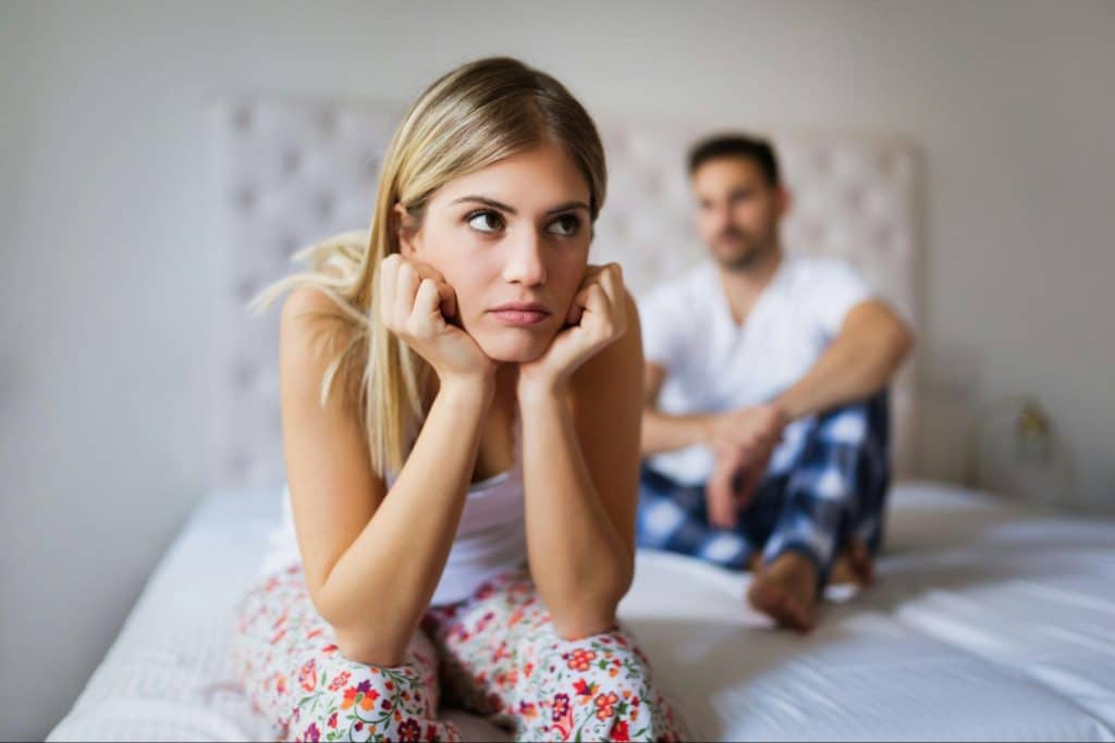 A man and woman at the bed