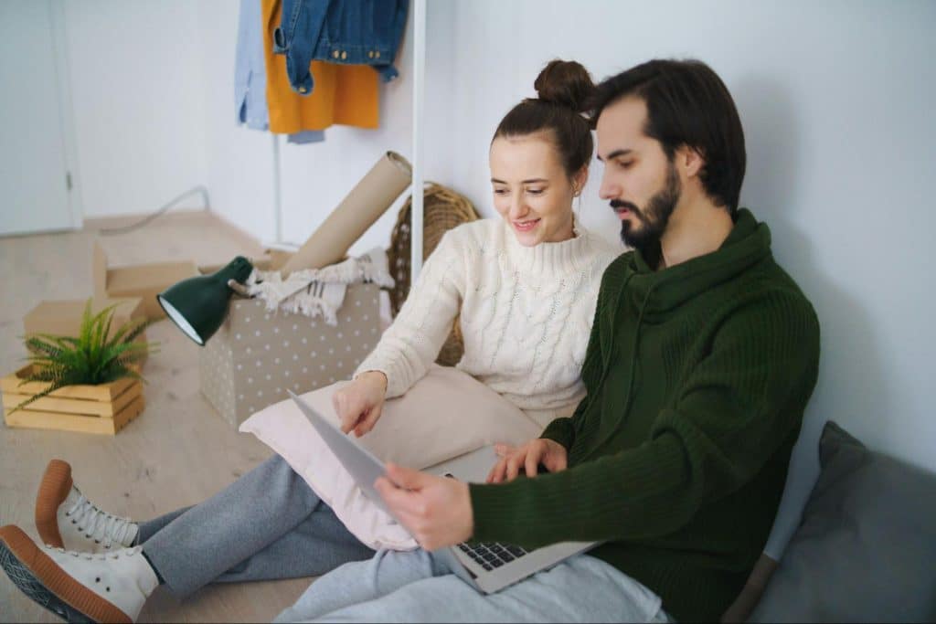 A man and woman looking at the laptop