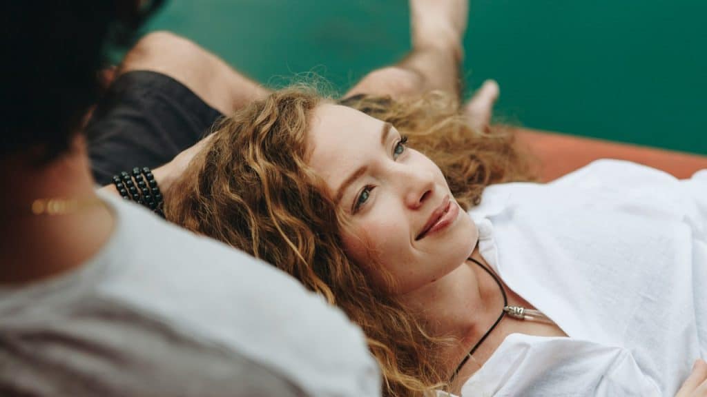 A woman relaxing in her boyfriend's lap.