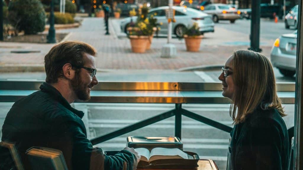 A man and a woman sitting while talking to each other.