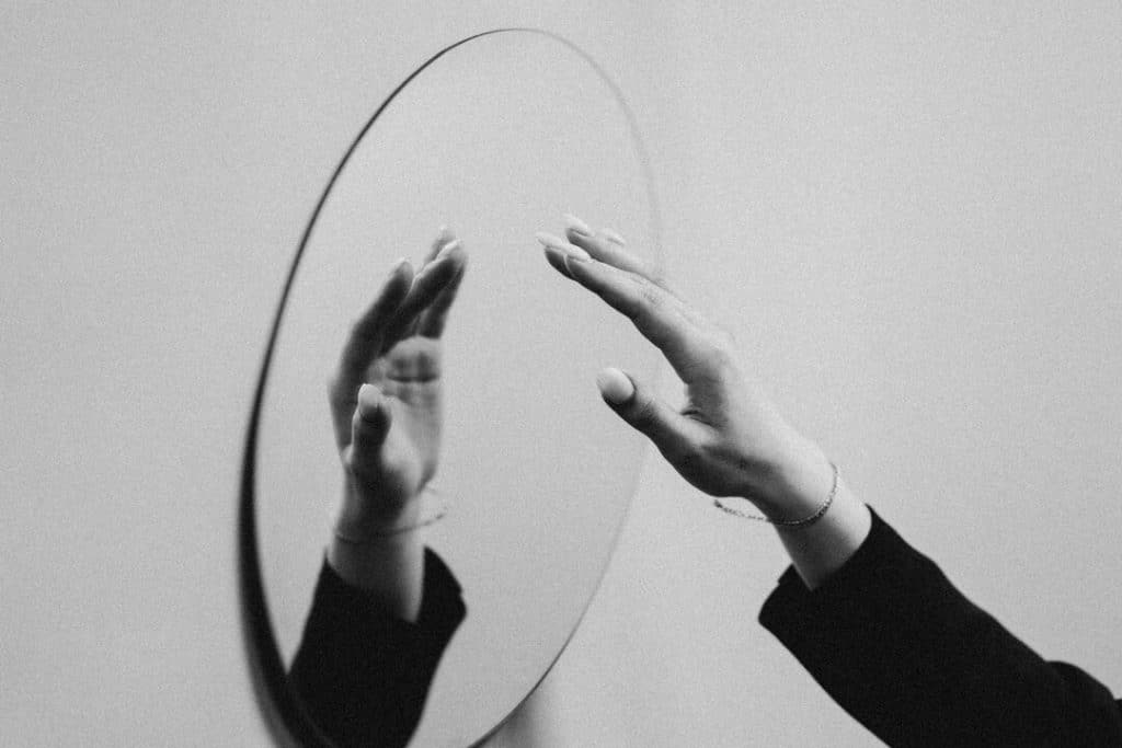 A person about to touch a mirror