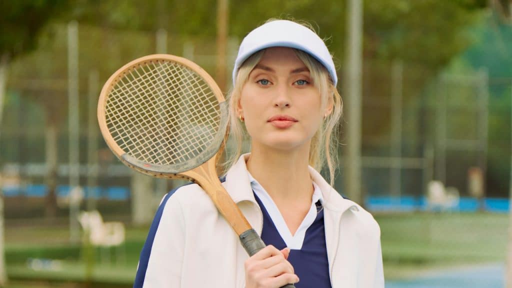 A woman holding a tennis racket while standing on a tennis court.