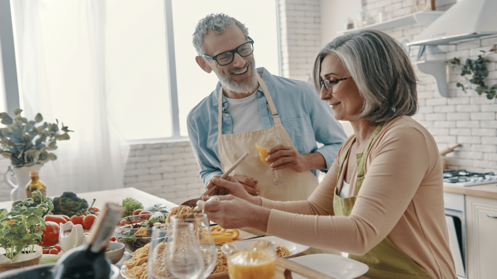 A couple laughing together while cooking