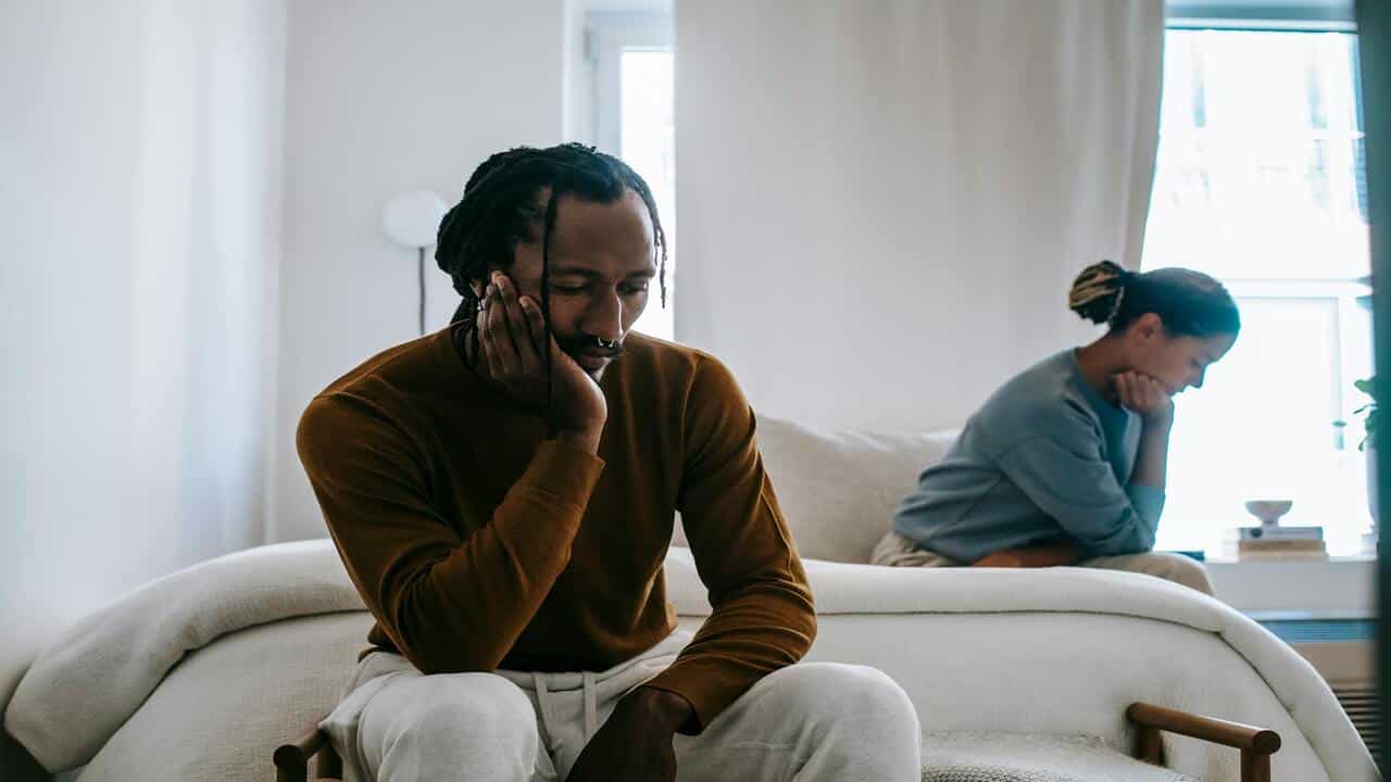 A couple looking sad in the bedroom
