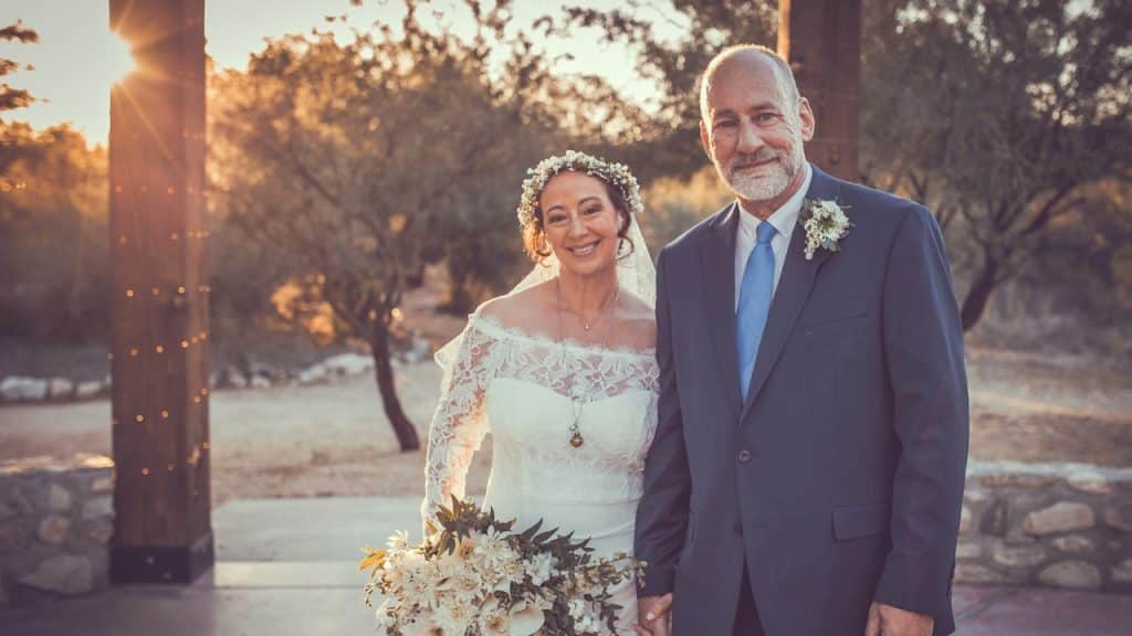 A bride and a groom standing next to each other.