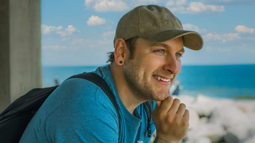 A man wearing a cap and smiling.