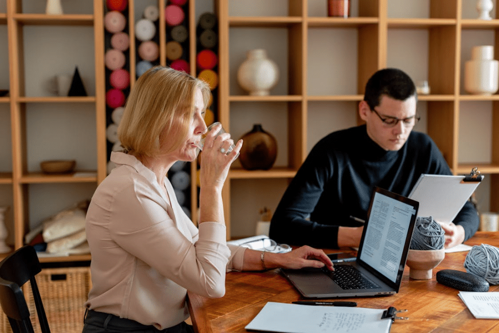 A Woman Drinking Water While Sitting at the Meeting Table