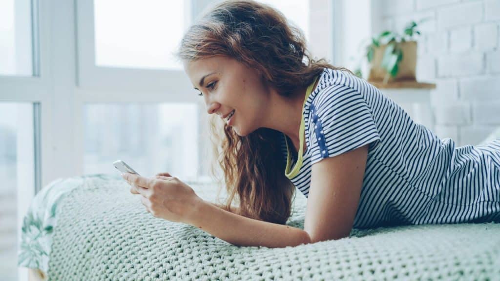 A woman smiling while texting