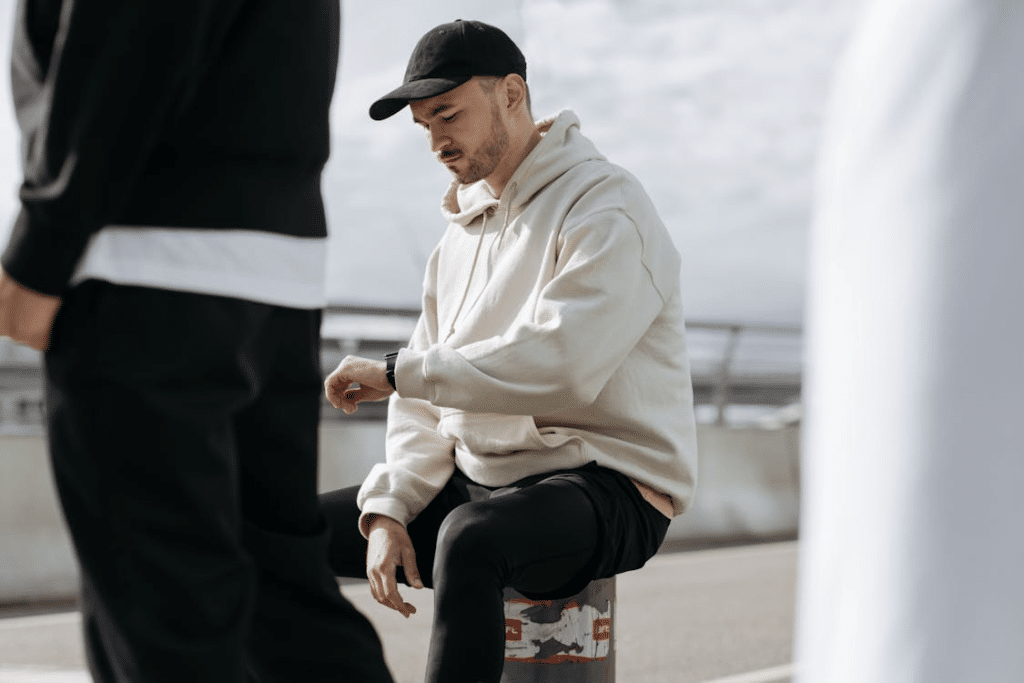A man in a hoodie sitting on the street