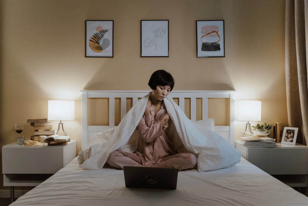 A woman sitting in the bed with a laptop