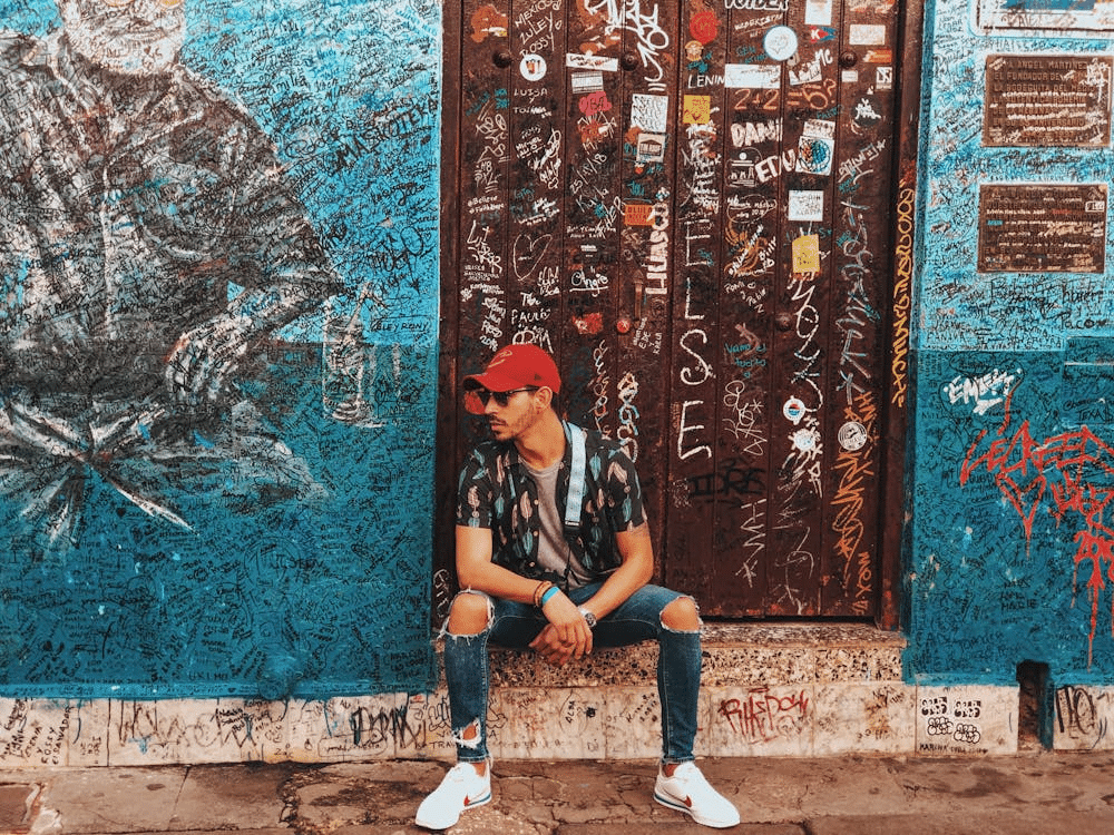 A man sitting on a doorstep with a dirty background