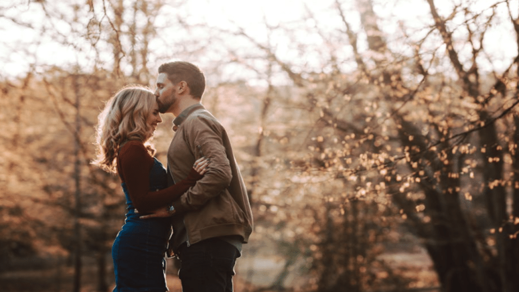 A man kissing his wife on the forehead