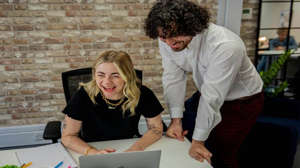 Colleagues laughing together in the office