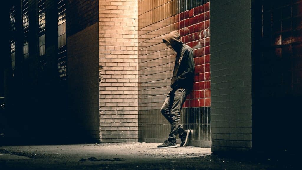 A man leaning on a concrete wall.