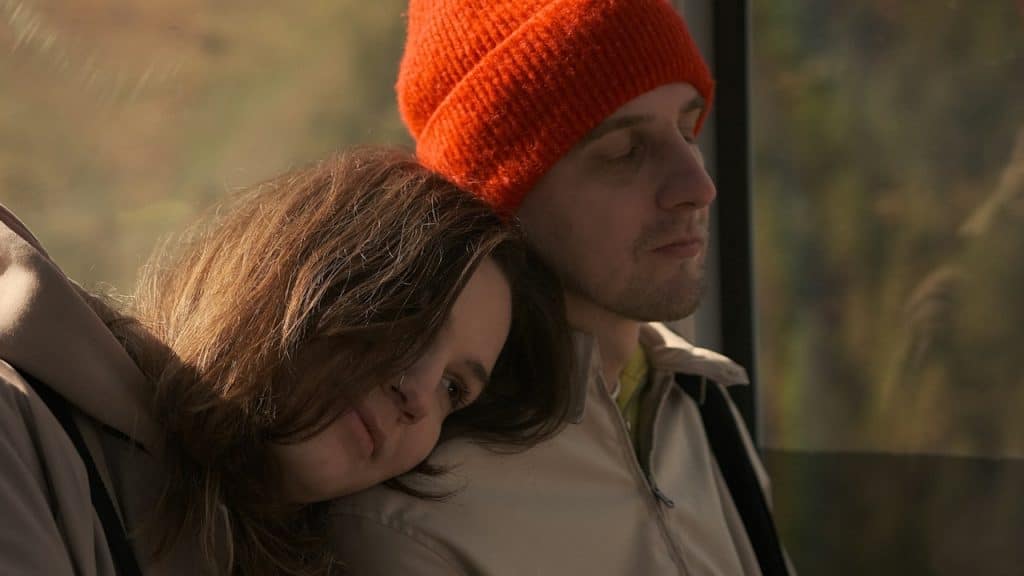 A woman leaning on a man’s shoulder.