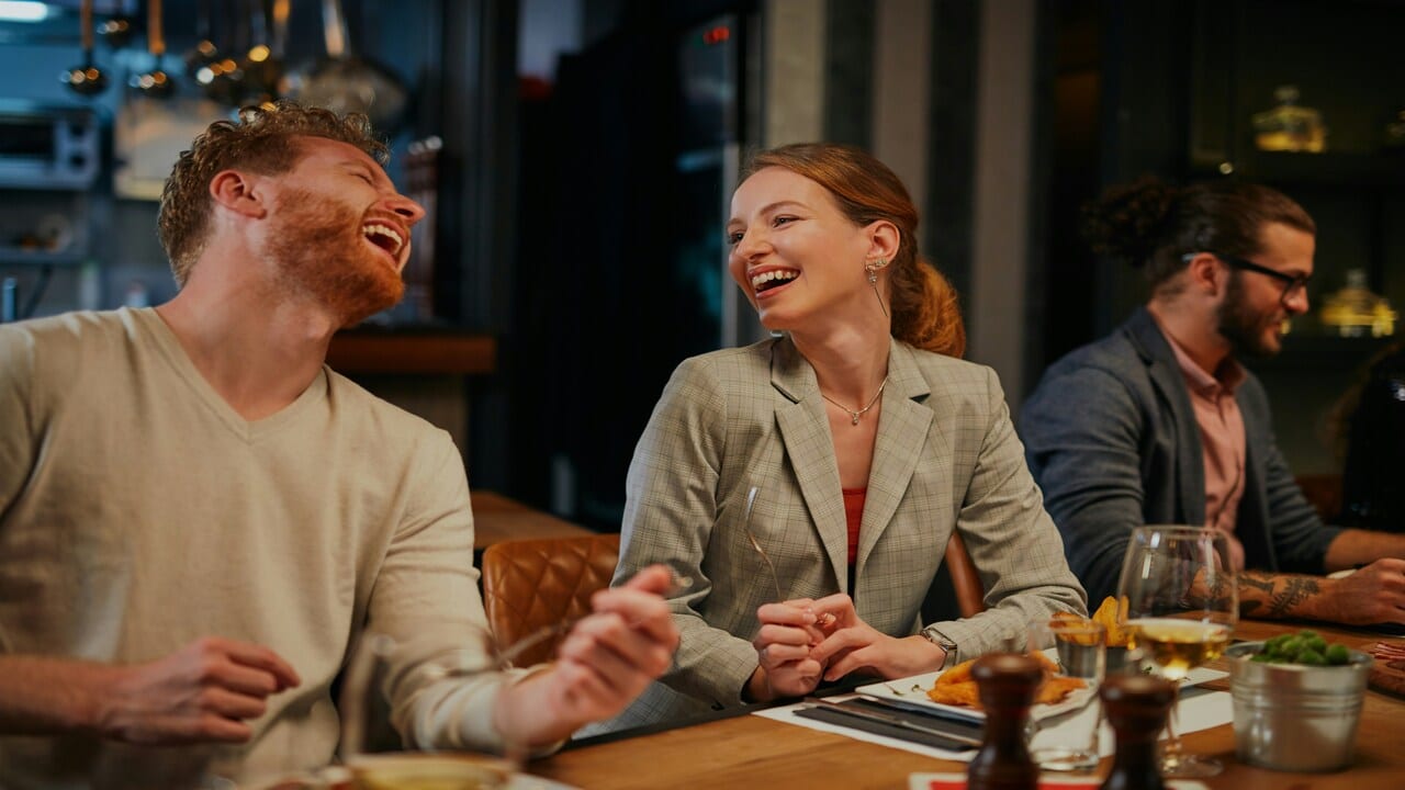 Colleagues laughing while having a meal