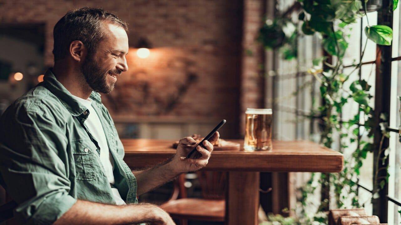 A man smiling while texting