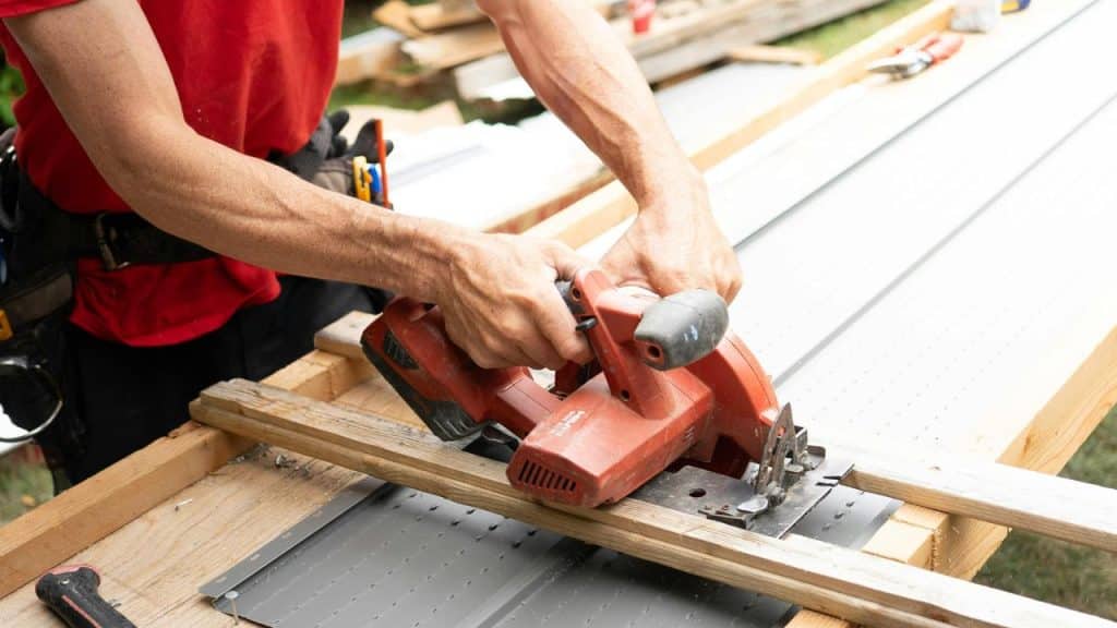 A person using a circular saw to cut wood on a workbench.