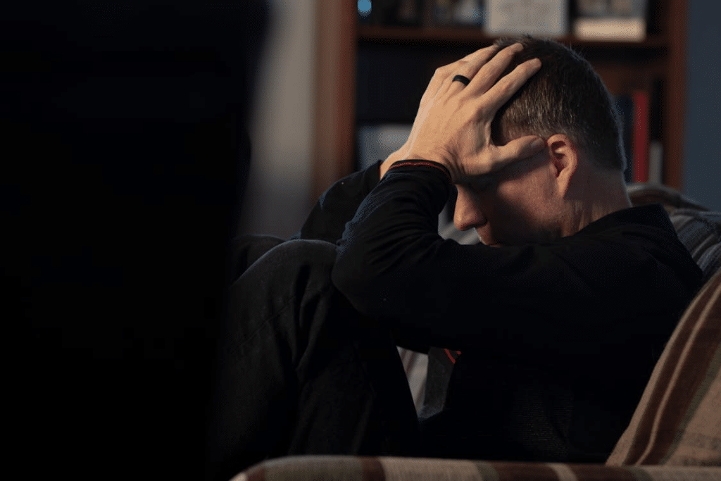 Man Sitting with Hands on Head